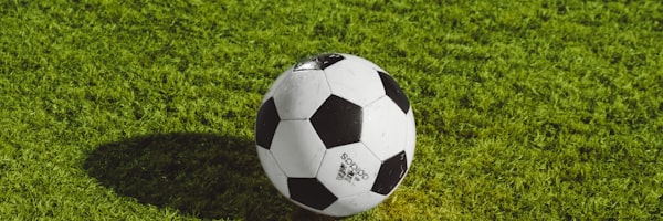 欧冠联赛深度分析文章配图 - 球员在欧冠标志前庆祝胜利